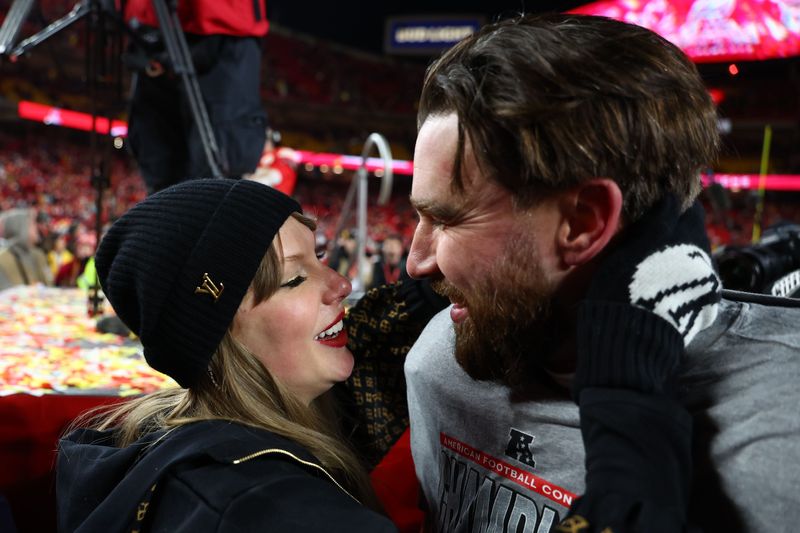 Recording artist Taylor Swift and Kansas City Chiefs tight end Travis Kelce (87) react after the AFC Championship game against the Buffalo Bills.