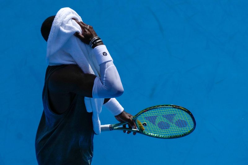 Francis Tiafoe wipes his face in the Cincinnati Open fourth round match between Francis Tiafoe and Holger Rune at the Lindner Family Tennis Center in Mason, Ohio, on Wednesday, Aug. 13, 2025. Rune advanced after Tiafoe retired in the second set.