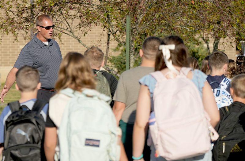 Principal Mike Norris helps welcome students to Louisville Elementary School on Tuesday, Aug. 19, 2025, for their first day of classes for the new school year.