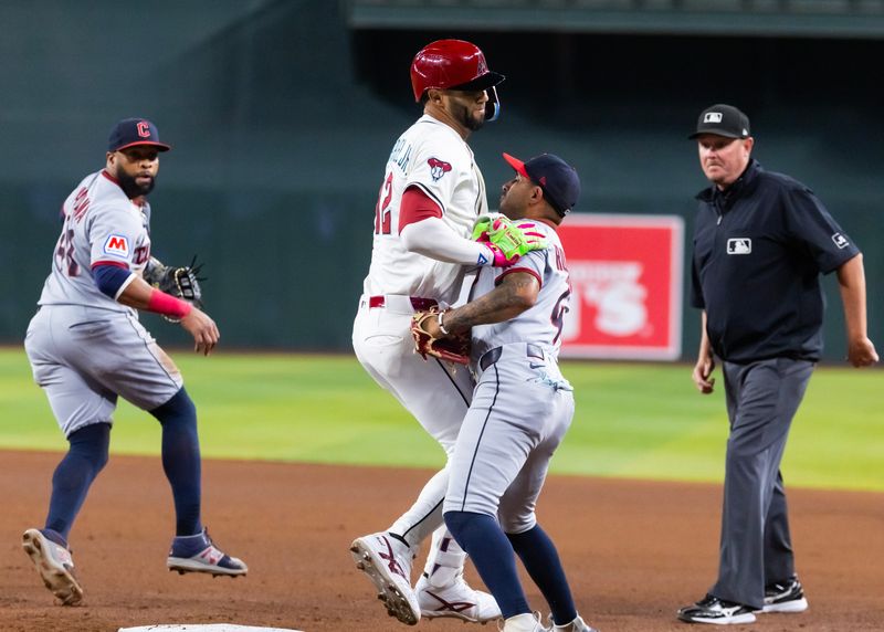 Aug 19, 2025; Phoenix, Arizona, USA; Arizona Diamondbacks base runner Lourdes Gurriel Jr. (12) collides with Cleveland Guardians infielder Brayan Rocchio on a play at first base in the fourth inning at Chase Field. Mandatory Credit: Mark J. Rebilas-Imagn Images