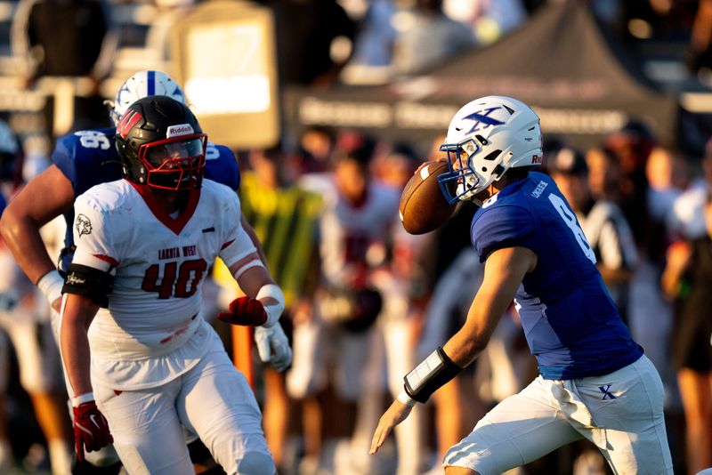 St. Xavier quarterback Jackson Frey (8) scrambles as holding is called in the second quarter between Lakota West and St. Xavier at St. Xavier High School in Cincinnati on Aug. 22, 2025.