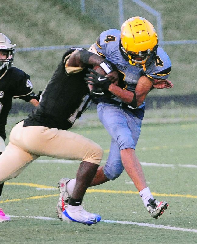 Akron North's Jaden Wardlaw is tackled by St. Thomas Aquinas' Tramell Childs, Friday Aug. 22, 2025.