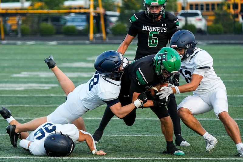 Evan Foust (5) of the Highland Hornets is brought down by Hudson defense, Aug. 29, 2025, at Highland High School in Granger Township, Ohio.
