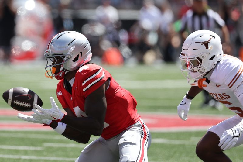 Aug 30, 2025; Columbus, Ohio, USA; Ohio State Buckeyes wide receiver Jeremiah Smith (4) makes a catch against Texas Longhorns defensive back Malik Muhammad (5) in the first half at Ohio Stadium. Mandatory Credit: Joseph Maiorana-Imagn Images