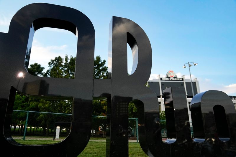 Ohio Stadium can be seen behind a Script Ohio sculpture during summer practice for the Ohio State Marching Band at Lincoln Tower Field on Aug. 13, 2025.
