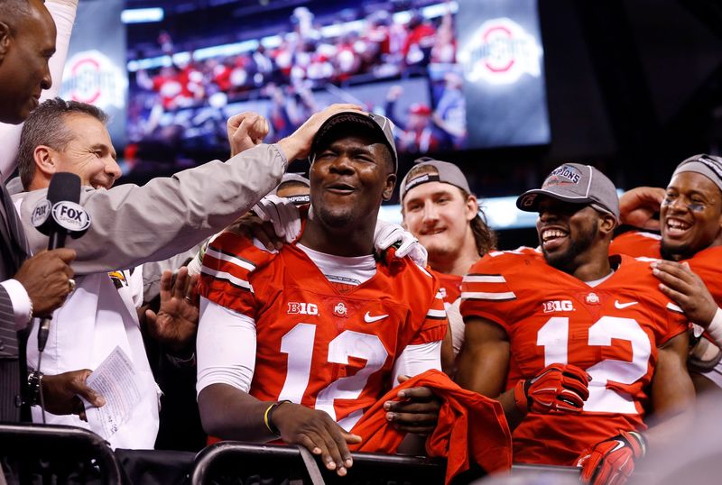 Ohio State Buckeyes head coach Urban Meyer gives quarterback Cardale Jones (12) a pat on the head as he is announced as the game's MVP following the 59-0 win over Wisconsin in the Big Ten Championship game at Lucas Oil Stadium in Indianapolis on Dec. 6, 2014. (Adam Cairns / The Columbus Dispatch)