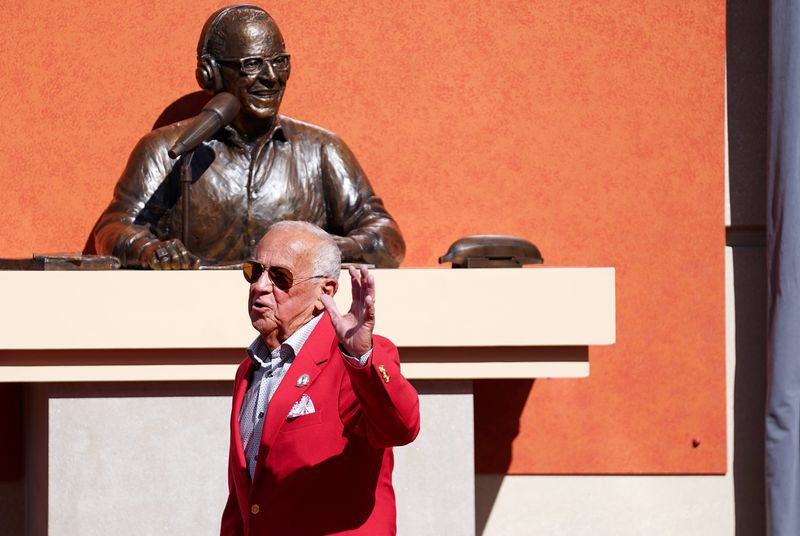 Reds Hall of Fame broadcaster Marty Brennaman waves to the crowd after the unveiling of his statue at Great American Ball Park.