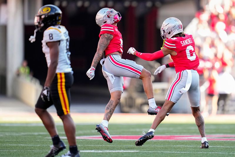Ohio State cornerback Aaron Scott Jr. celebrates a stop with teammate Devin Sanchez during a 70-0 win over Grambling State on Sept. 6.