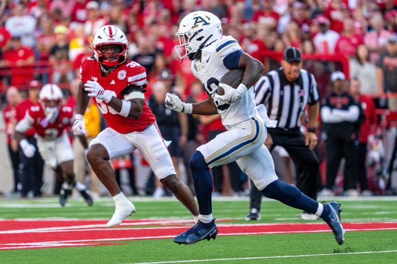 Sep 6, 2025; Lincoln, Nebraska, USA; Akron Zips running back Sean Patrick (13) runs against Nebraska Cornhuskers linebacker Marques Watson-Trent (33) during the first quarter at Memorial Stadium. Mandatory Credit: Dylan Widger-Imagn Images