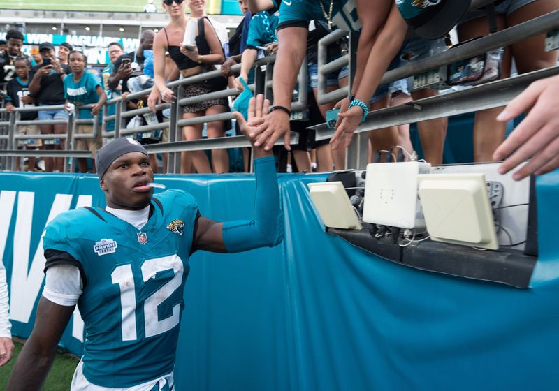 Jacksonville Jaguars wide receiver Travis Hunter (12) gives high-fives and signed autographs after the game between the Carolina Panthers at Jacksonville Jaguars at EverBank Stadium Sunday September 7, 2025. Jaguars defeated the Panthers 26-10. [Doug Engle/Florida Times-Union]