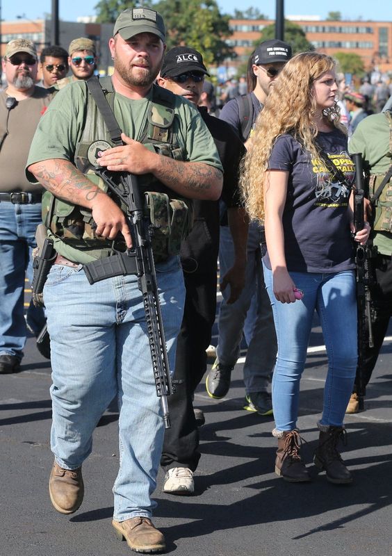 Gun rights activist Kaitlin Bennett, right, marches with fellow supporters on the Kent State University campus on Sept. 29, 2018, in Kent.