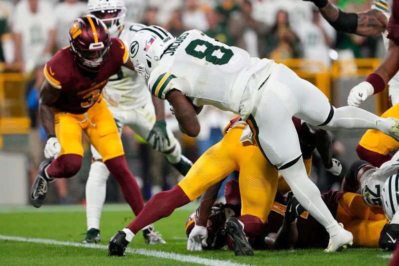 Sep 11, 2025; Green Bay, Wisconsin, USA; Green Bay Packers running back Josh Jacobs (8) scores a touchdown against the Washington Commanders in the second quarter at Lambeau Field. Mandatory Credit: Jeff Hanisch-Imagn Images