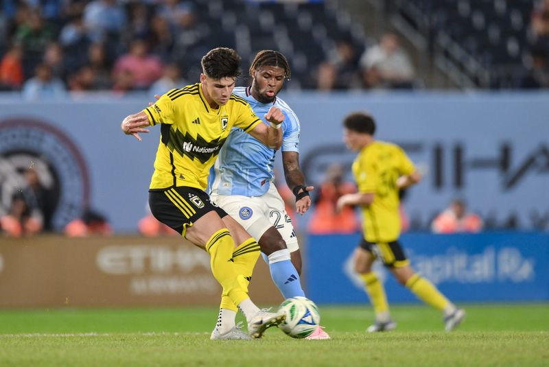 Sep 17, 2025; Bronx, New York, USA; Columbus Crew forward Max Arfsten (27) passes the ball as New York City defender Tayvon Gray (24) defends during the first half at Yankee Stadium. Mandatory Credit: John Jones-Imagn Images