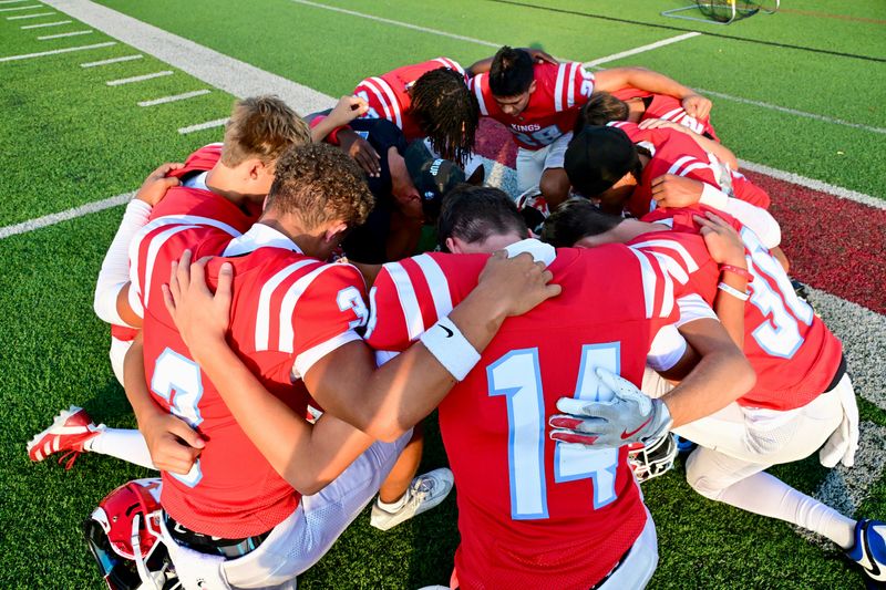 Kings players total up for prayer before the start of their game against Anderson in the Sept. 19, 2025, Eastern Cincinnati Conference football matchup.