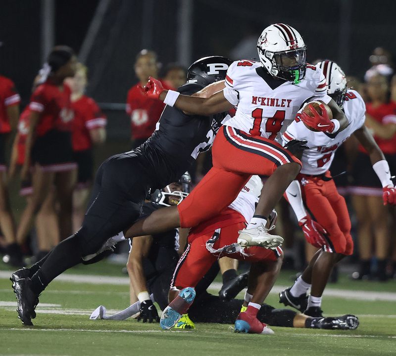 McKinley's Kyelin West tries to jump past a Perry tackler at Wakefield Stadium on Friday, Sept. 19, 2025.