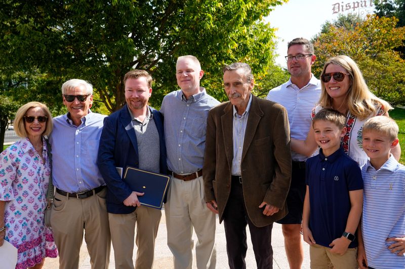 The family of Joe Carr takes a photo with NFL Films head archivist Chris Willis during a historical marker dedication for the first NFL office building Sept. 20 outside the Ohio Statehouse in Columbus.