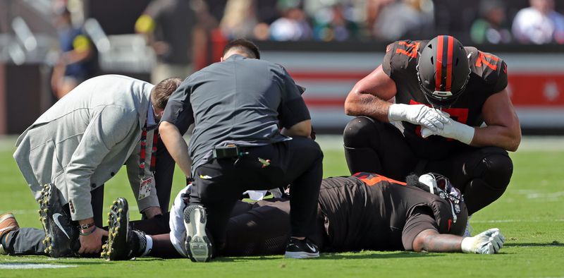 Cleveland Browns medical staff and guard Wyatt Teller (77) check on offensive tackle Dawand Jones after he was injured in a game against the Green Bay Packers on Sept. 21, 2025, in Cleveland.