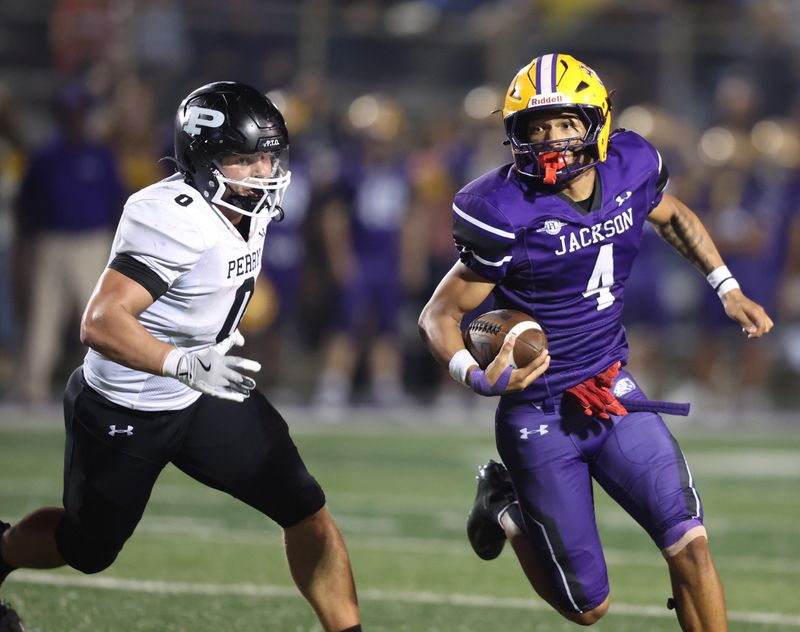 Jackson's Corey Jacobs turns the corner as Perry's Connor Shephard pursues during a high school football game at Jackson Friday, Sept. 26, 2025.