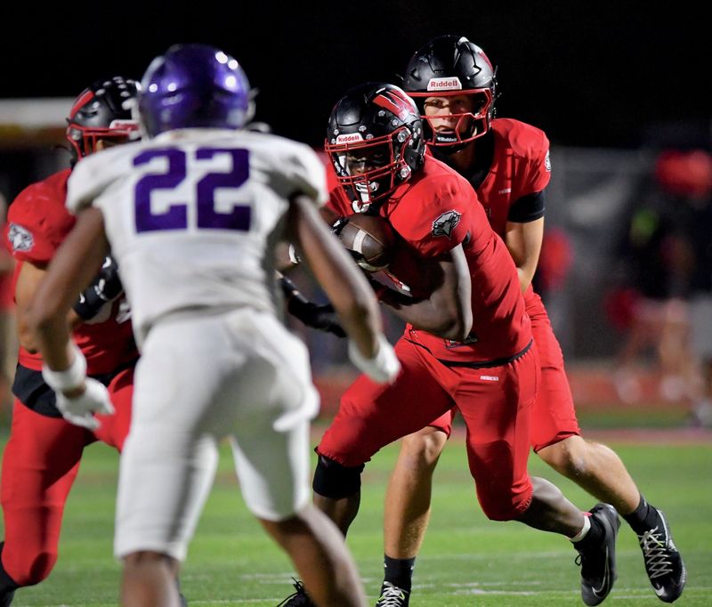 Lakota West's Jackson Smith hands the ball off to Kenyon Norman in the second half of the Firebirds 27-13 victory over Middletown on Friday, Sept. 26, 2025, at Lakota West High School.