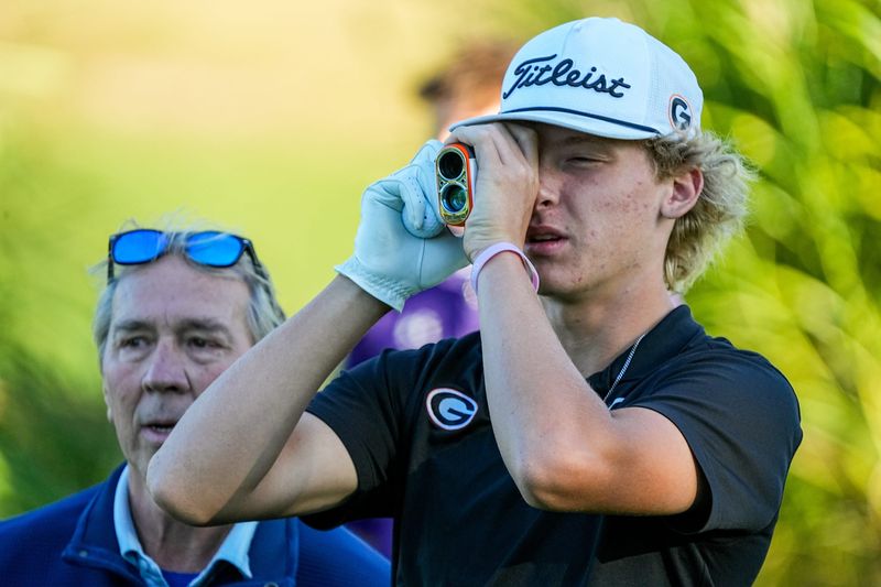 Green’s Chad Tietz reads yardage from the first tee during an OHSAA D1 Boys District Golf match, Oct. 6, 2025, at Pine Hills Golf Club in Hinckley, Ohio.