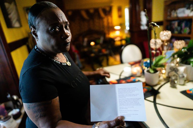 Yvette McIntyre-Allen shows the in-memoriam inscription from the funeral of her son, Ontario Bradley, Oct. 7, 2025, in her Akron, Ohio home. Ontario was killed in May of 2025.