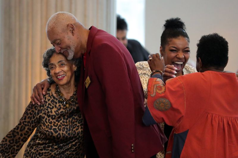 Anita Brown, left facing, hugs Frank Williams before her late husband, Virgil, is inducted into the 2025 Summit County Sports Hall of Fame, Oct. 7, 2025, in Akron, Ohio.