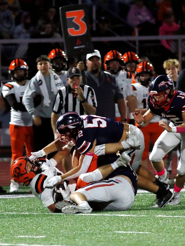 Titan Peterman, top, and Brogan O'Connor bring down Talon Carns for a loss during the first quarter of Indian Valley's 42-14 win against visiting Ridgewood on Friday, Oct. 10, 2025, in Gnadenhutten, Ohio. Peterman, an end, finished with three tackles for loss.