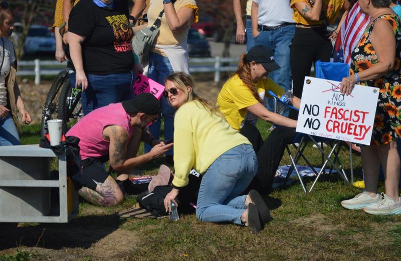 People attend to a woman who was struck a by a hit-and-run driver during the "No Kings" protest on Fulton Drive NW in Jackson Township on Oct. 18.