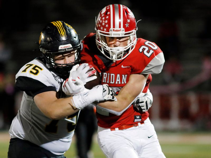 Tri-Valley's Lane Taylor, left, wraps up Logan Russell during a 35-29 double-overtime win against visiting Sheridan on Friday, Oct. 17, 2025, in Thornville, Ohio.