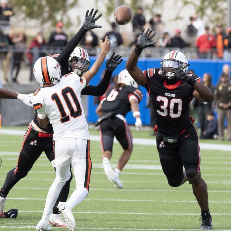 Massillon’s Mandwel Patterson beats the pressure of McKinley’s Collin Hinkle and Antonio Stevens (30) to complete a pass to the 25-yard line and a first down Saturday, Oct. 25, 2025.