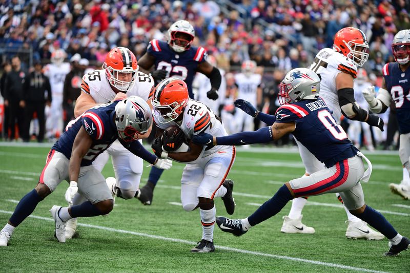 Oct 26, 2025; Foxborough, Massachusetts, USA; Cleveland Browns running back Dylan Sampson (22) runs with the ball defended by New England Patriots safety Jaylinn Hawkins (21) and corner back Christian Gonzalez (0) during the fourth quarter at Gillette Stadium. Mandatory Credit: Bob DeChiara-Imagn Images