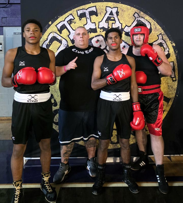 Tylar Keith of the Coshocton Boxing Club stands with his students Mobius Williams, Montara Johnson and Zander Spring at a boxing tournament in Waynesboro, Virginia.