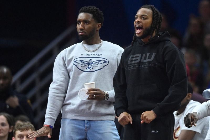 Cleveland Cavaliers guard Donovan Mitchell (left) and guard Darius Garland react on the bench during a game against the Toronto Raptors on Oct. 31, 2025, in Cleveland.