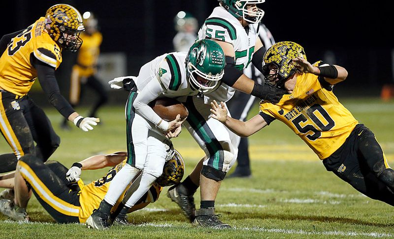 Colonel Crawford High School's Payne DeGray (78) and Walker Cramer (50) tackle Reedsville Eastern High School's Braxton Yonker (4) during OHSAA Division VI regionals first round high school football action Friday, Oct. 31, 2025 at Colonel Crawford High School. TOM E. PUSKAR/MANSFIELD NEWS JOURNAL