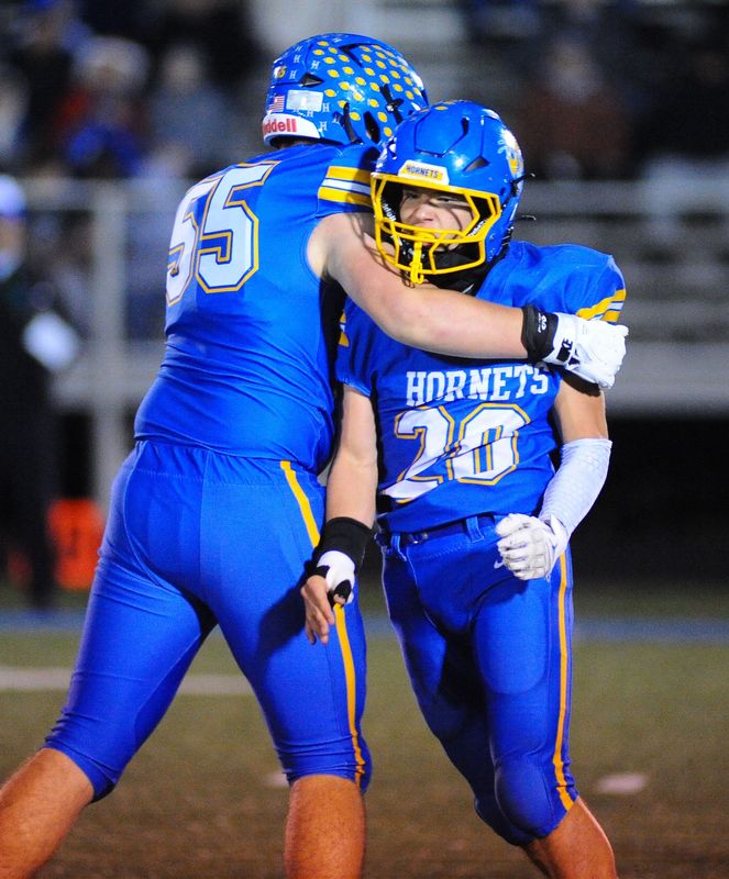 East Canton's Dillon Anderson (20) celebrates with teammate Maverick Campbell after making a sack in a playoff game against Lisbon, Friday, Oct. 31, 2025.