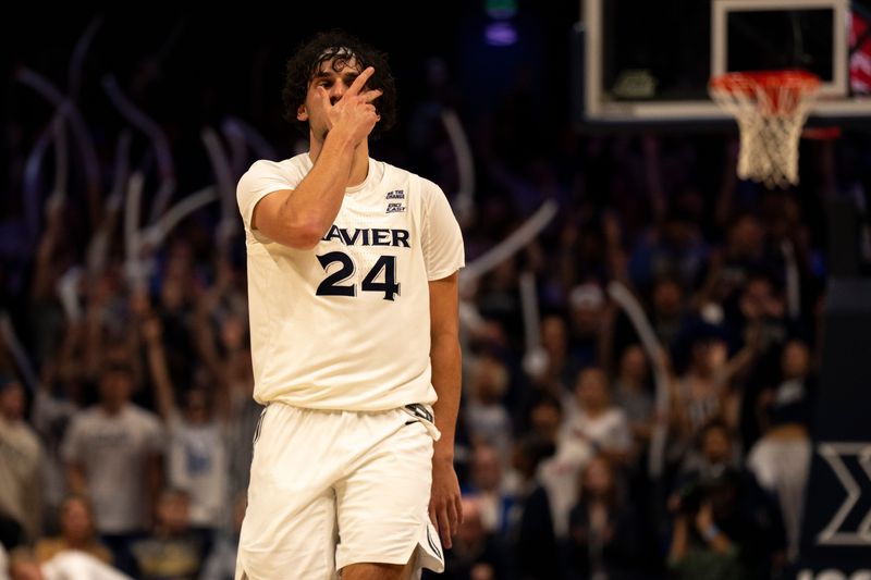 Xavier Musketeers forward Jovan Milicevic (24) reacts to hitting a 3-point shot over Marist Red Foxes forward Jaden Daughtry (11) defends in the second half of the basketball game at the Cintas Center on Nov. 3, 2025.