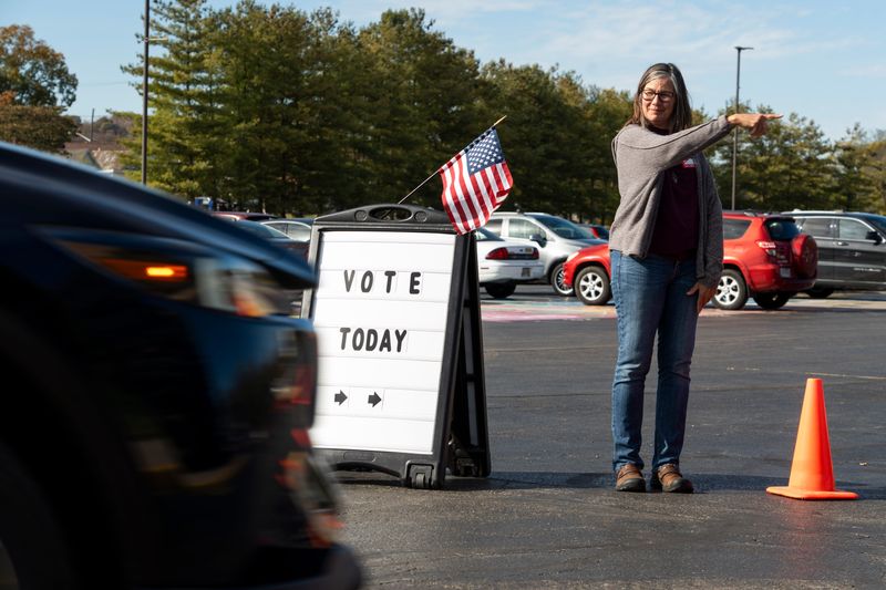 Poll worker Dona Meyer, of Chillicothe, guides local residents on where to park in the parking lot at Chillicothe High School helping them find their way to the side door of the high school where they could enter the gymnasium to cast their vote for the Ross County General Election on Nov. 4, 2025, in Chillicothe, Ohio.
