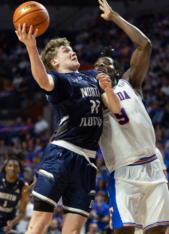 Florida center Rueben Chinyelu (9) blocks North Florida forward Trey Cady (22) during the first half of an NCAA basketball game at Steven C. O'Connel Center Exactech Areana in Gainesville, FL on Thursday, November 6, 2025. [Alan Youngblood/Gainesville Sun]