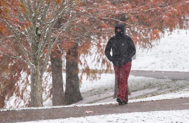 The first snowfall of the season didn't keep this walker from getting in steps at Winton Woods Park Monday November. 10, 2025.
