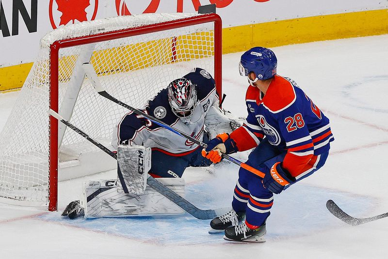 Nov 10, 2025; Edmonton, Alberta, CAN; Edmonton Oilers forward Jack Roslovic (28) scores during overtime against Columbus Blue Jackets goaltender Jet Greaves (73) at Rogers Place. Mandatory Credit: Perry Nelson-Imagn Images