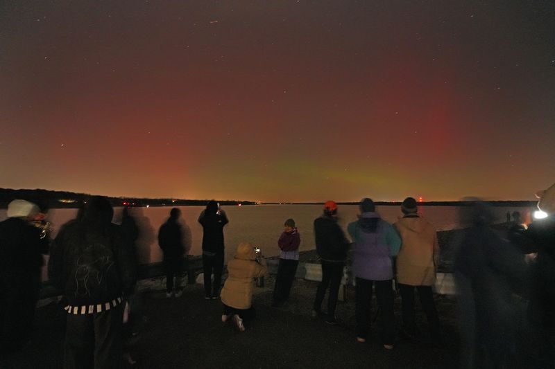 People enjoy the Northern Lights at Alum Creek State Park dam Wednesday, Nov. 12, 2025. The Northern Lights, also known as Auroras, are ribbons of light weaving across Earth's northern or southern polar regions, according to NASA. They are caused by magnetic storms that have been triggered by solar activity, such as solar flares or coronal mass ejections. Energetic charged particles from these events are carried away from the sun by the solar wind.