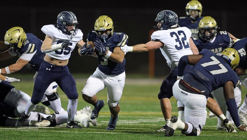Archbishop Hoban running back Jance Henry (3) gets past Hudson defensive lineman MJ Manes (55) and linebacker Joseph Cavalcanti (32) as he runs for a first down during the first half of a Division II regional semifinal football game, Nov. 14, 2025, in Akron, Ohio.