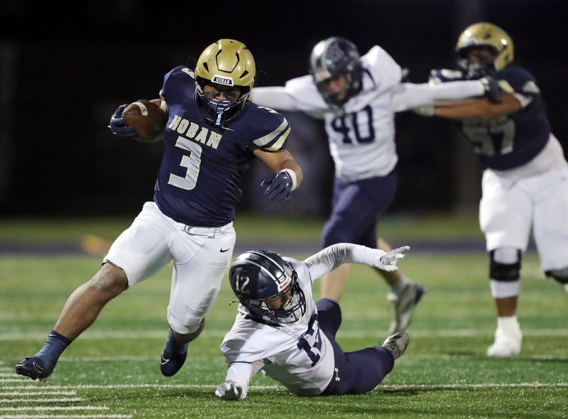 Archbishop Hoban running back Jance Henry (3) breaks away for a big run ahead of Hudson defensive back Evan Wolenski (12) during the first half of a Division II regional semifinal football game, Nov. 14, 2025, in Akron, Ohio.
