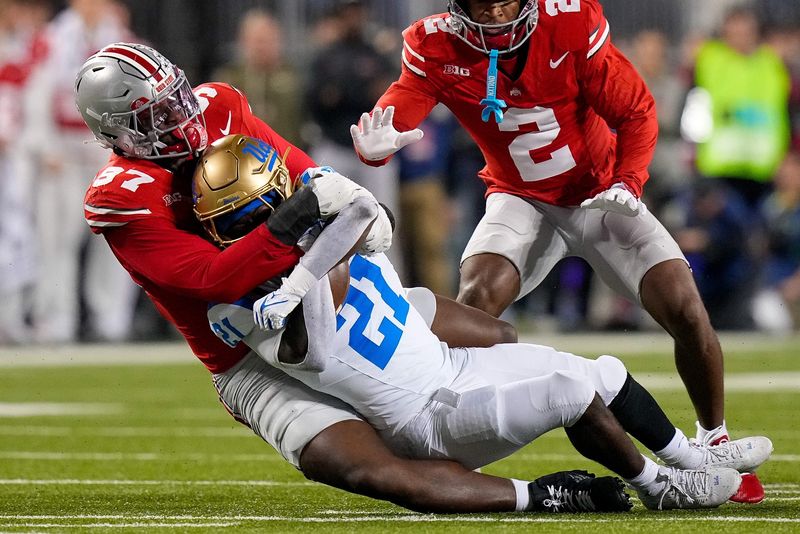 Ohio State Buckeyes defensive end Kenyatta Jackson Jr. (97) tackles UCLA Bruins running back Jaivian Thomas (21) in the first half of the NCAA college football game at Ohio Stadium on Saturday, Nov. 15, 2025 in Columbus, Ohio.