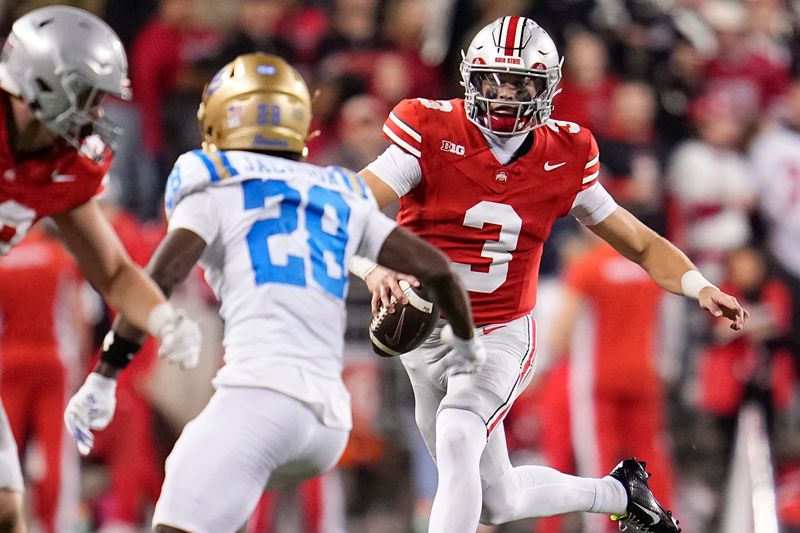 Ohio State Buckeyes quarterback Lincoln Kienholz (3) runs at UCLA Bruins defensive back Scooter Jackson (28) during the NCAA football game at Ohio Stadium in Columbus on Nov. 15, 2025. Ohio State won 48-10.