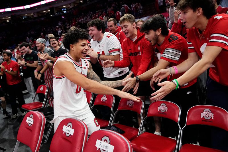 Ohio State Buckeyes guard John Mobley Jr. (0) celebrates with students following the men's NCAA basketball game against the Notre Dame Fighting Irish at Value City Arena in Columbus on Nov. 16, 2025. Ohio State won 64-63.