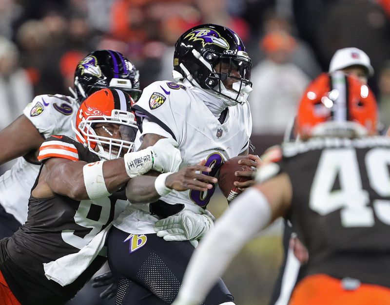 Cleveland Browns defensive end Myles Garrett (95) gets to Baltimore Ravens quarterback Lamar Jackson (8) during the second half of an NFL football game at Huntington Bank Field, Nov. 16, 2025, in Cleveland, Ohio.