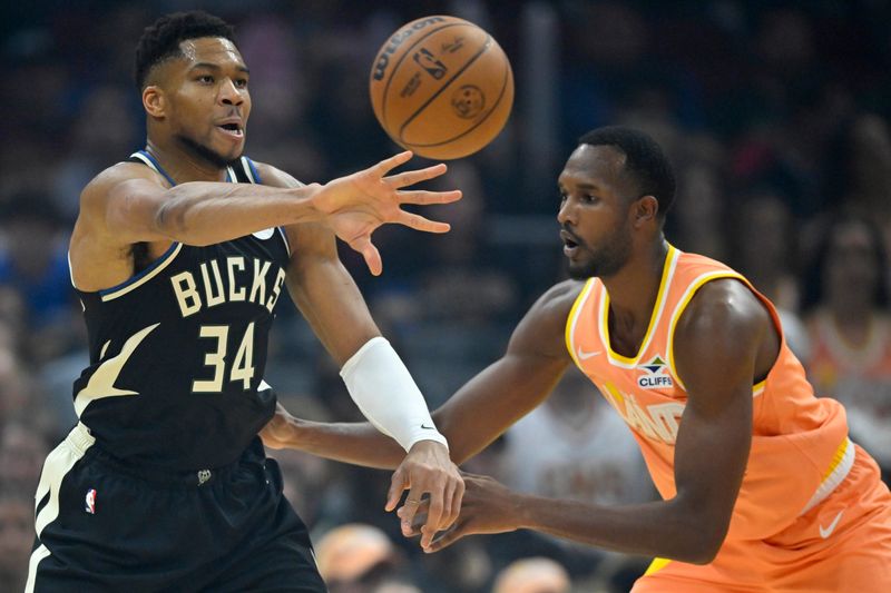 Milwaukee Bucks forward Giannis Antetokounmpo throws a pass as Cavaliers forward Evan Mobley defends in the first quarter, Nov. 17, 2025, in Cleveland.