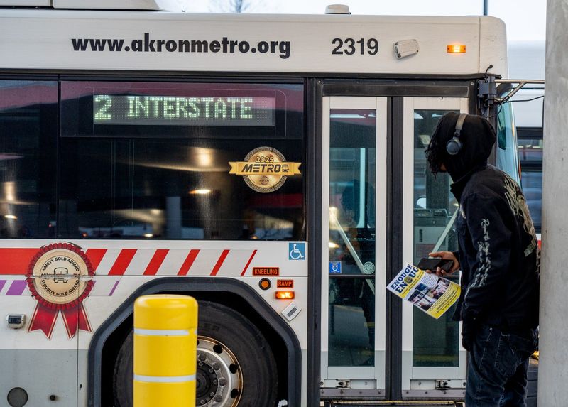 A passenger holds a flyer given to him by a union member. Transport Workers Union Local 1, representing bus operators, vehicle service and clerical workers at Akron's Metro Transit Authority, react to the 17 months without a contract in Akron on Nov. 20, 2025.