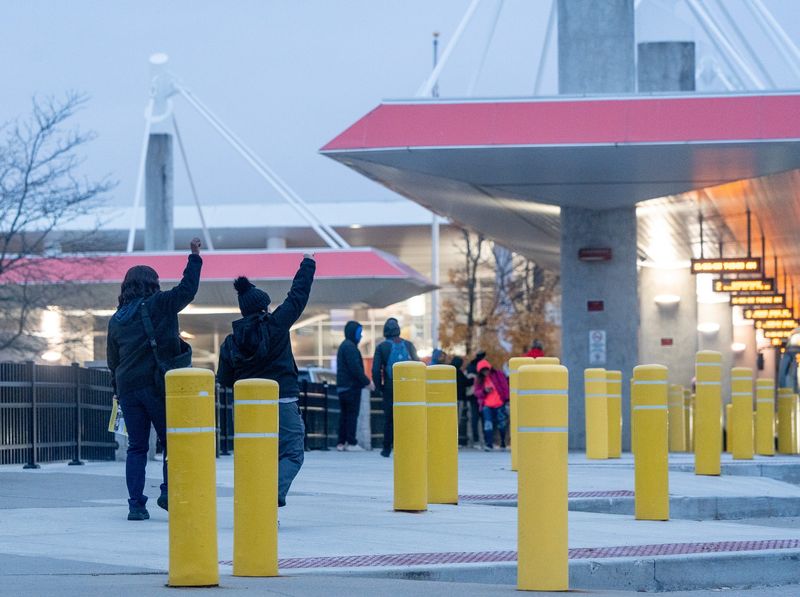 Employees raise fists to honking support from departing busses. Transport Workers Union Local 1, representing bus operators, vehicle service and clerical workers at Akron's Metro Transit Authority, react to the 17 months without a contract in Akron on Nov. 20, 2025.